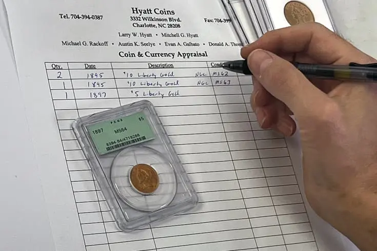 A coins appraisal sheet being written , on top of it a copper graded coin case.